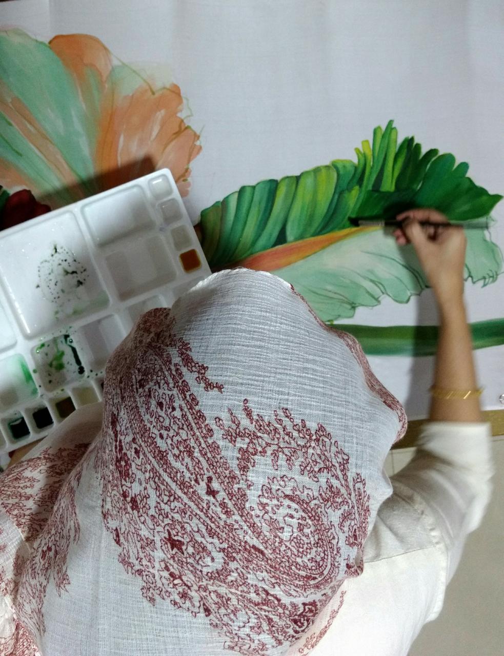 Husna Rafath K. hand-painting a botanical leaf on silk in her studio