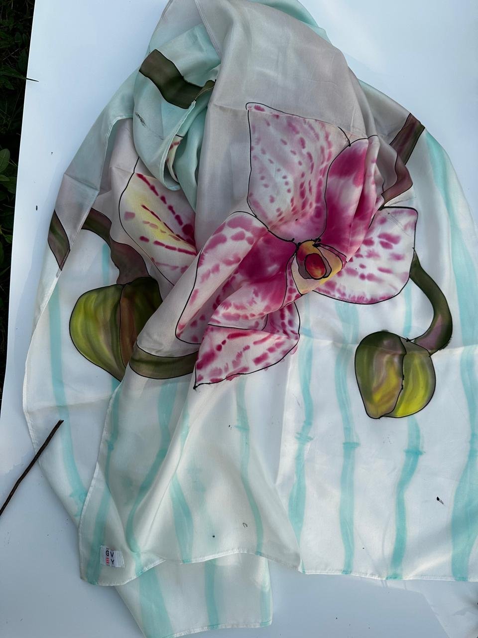Hand-painted orchid on a teal-striped silk scarf